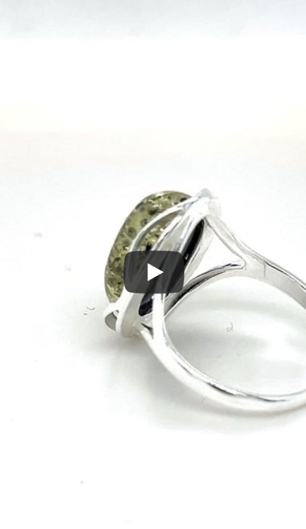 Ring mit grünem Bernstein an der Hand