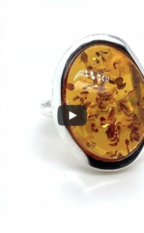 Silberner Ring mit Bernstein am Finger getragen