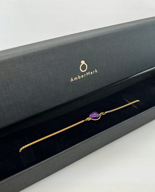 handgefertigtes schmuckstueck mit violettem edelstein